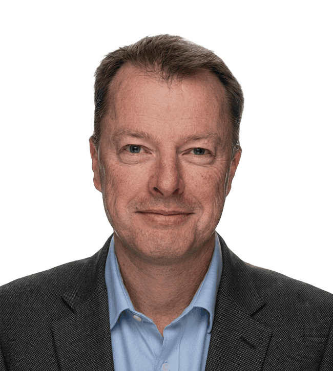 Professional headshot of a middle-aged man wearing a dark blazer and light blue dress shirt, facing the camera with a slight smile.