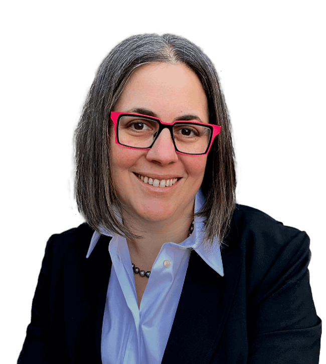 Smiling woman with shoulder-length gray hair and pink glasses, wearing a light blue shirt and dark blazer, looking at the camera.